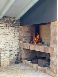 een stenen open haard met een vuur erin bij Family-sized renovated Istrian house w/lavand field - 20min from Rovinj. in Žminj