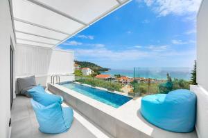 a view of the ocean from the balcony of a house at Mythodea Prive Luxury Suites in Chrysi Ammoudia