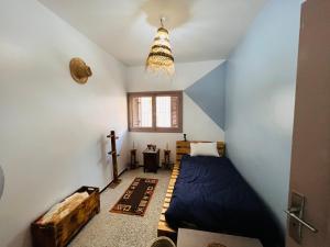 1 dormitorio con cama, ventana y lámpara de araña en sweet house fes, en Fez