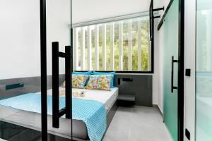 a small bedroom with a bed and a window at Mythodea Prive Luxury Suites in Chrysi Ammoudia
