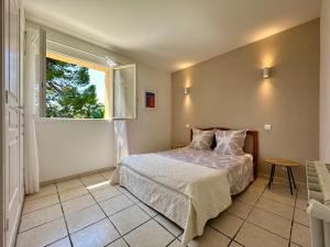 a bedroom with a bed and a window at Villa Marinette in Juan-les-Pins