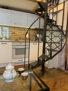 cocina con mesa de cristal y escalera de caracol en Family Suite, en Cracovia