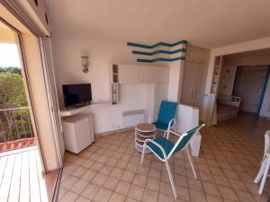 une chambre avec des chaises et une cuisine avec un balcon dans l'établissement Location à banyuls vue panoramique, à Banyuls-sur-Mer