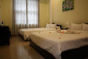 Dos camas en una habitación de hotel con velas en Jade Hotel, en Hue