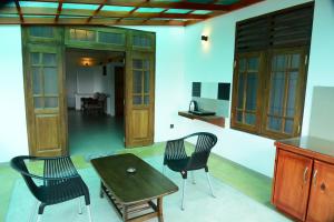 a living room with a wooden table and chairs at Sadisa Villa in Hikkaduwa