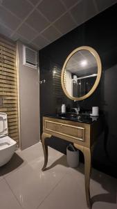 ein Bad mit einem Waschbecken und einem Spiegel in der Unterkunft The Logo Family Apart in Altınkum