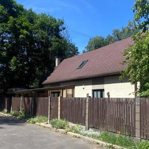una casa con una valla y un techo marrón en Zeltini, en Riga