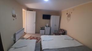 um pequeno quarto com 2 camas e um frigorífico em Centrala em Vrdnik