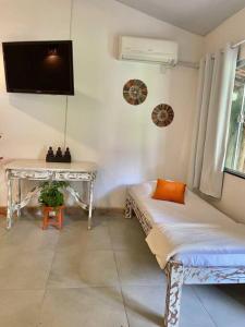 een kamer met een tafel, een bed en een bureau bij Casa Bali 1 2 3 in Niterói