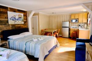 a bedroom with two beds and a kitchen with a table at The Landings Inn and Cottages at Old Orchard Beach in Old Orchard Beach