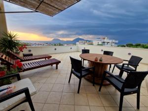 patio ze stołem i krzesłami oraz widokiem na ocean w obiekcie V for the View w mieście Patras