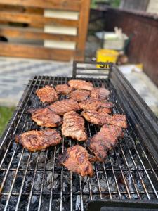 un montón de carne cocinando en una parrilla en Casa Chindris, en Ocna Şugatag