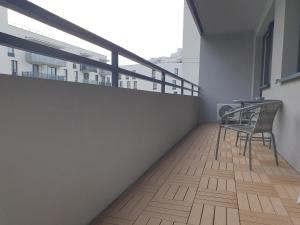 een balkon met 2 stoelen en een tafel. bij Apartament 45 in Wrocław