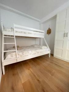 a bedroom with two bunk beds and a wooden floor at UIM Mediterraneo PB Virgen del Carmen Wifi in Puerto de Sagunto