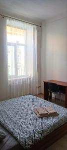 1 dormitorio con cama, escritorio y ventana en 2х кімнатна квартира у Львові поряд з залізничним вокзалом en Leópolis