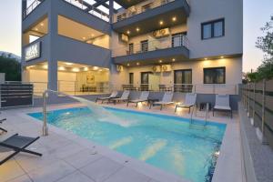 a house with a swimming pool in front of a building at MAKexclusive in Leptokarya