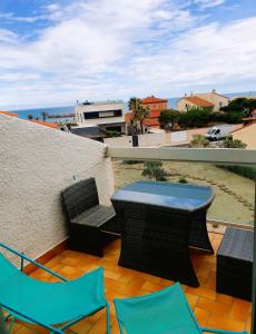 a patio with a table and chairs on a balcony at La Plage Du Lido in Le Barcarès