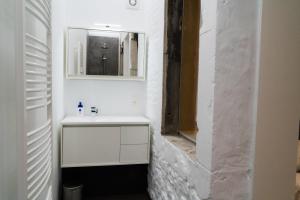uma casa de banho branca com um lavatório e um espelho em Cheval Blanc - Holiday Rental em Aubel