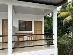- une vue sur la terrasse couverte à l'avant d'une maison dans l'établissement Tuanis Guest House, à Tortuguero