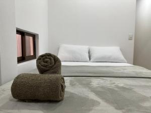 a bed with a pile of towels on top of it at Tuanis Guest House in Tortuguero