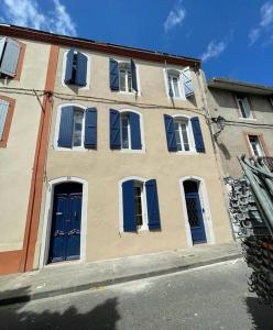 a building with blue doors and windows on a street at Escapade détente au cœur de Pamiers in Pamiers
