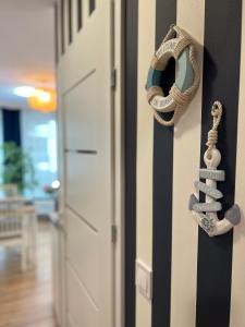 une porte avec une couronne nautique sur un mur dans l'établissement Apartament przy morzu W22, à Rowy
