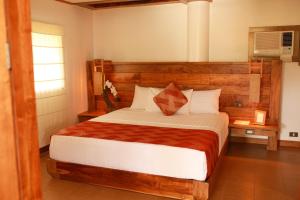 Schlafzimmer mit einem großen Bett mit einem Kopfteil aus Holz in der Unterkunft Boffo Resort in Loon