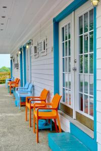 a row of colorful chairs on the side of a building at The Landings Inn and Cottages at Old Orchard Beach in Old Orchard Beach