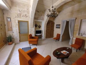 a large living room with orange chairs and a table at Charming rustic getaway in Xaghra, Gozo. in Xagħra