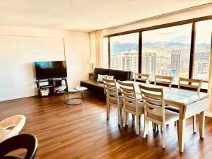 a living room with a table and chairs and a couch at Waikiki Panoramic Ocean View in Honolulu