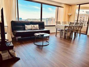 a living room with a couch and a table with chairs at Waikiki Panoramic Ocean View in Honolulu