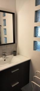 La salle de bains est pourvue d'un lavabo et d'un miroir. dans l'établissement home sweet home, à Plérin
