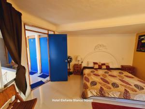 a bedroom with a bed and a large window at HOSTAL DEL ELEFANTE in Tepoztlán