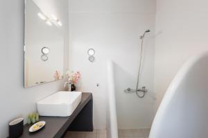 a white bathroom with a sink and a shower at Anzuelo Apartments in Megalochori