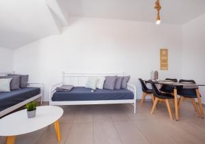 a living room with a bed and a table and chairs at Anzuelo Apartments in Megalochori +36 photos