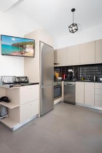 a kitchen with white cabinets and stainless steel appliances at Anzuelo Apartments in Megalochori