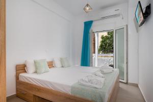a bedroom with a bed and a window at Anzuelo Apartments in Megalochori