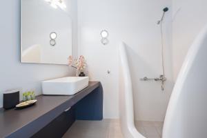 a bathroom with a white sink and a shower at Anzuelo Apartments in Megalochori