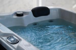 a bathtub filled with blue water with a chair in it at Anzuelo Apartments in Megalochori