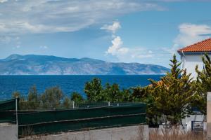a view of the ocean and a white building at Anzuelo Apartments in Megalochori