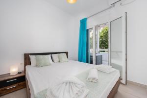 a bedroom with a bed and a large window at Anzuelo Apartments in Megalochori