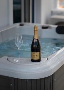 a bottle of champagne and a wine glass in a tub at Anzuelo Apartments in Megalochori