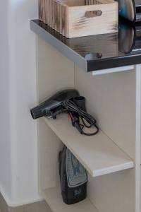 a shelf in a kitchen with a hair dryer at Anzuelo Apartments in Megalochori