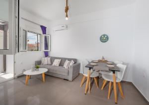 a living room with a couch and a table and chairs at Anzuelo Apartments in Megalochori