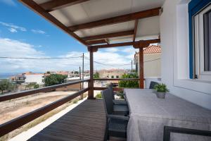 a patio with a table and chairs on a balcony at Anzuelo Apartments in Megalochori
