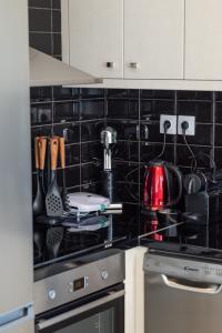 a black tiled kitchen with a stove top oven at Anzuelo Apartments in Megalochori