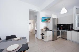 a kitchen with white cabinets and a table and chairs at Anzuelo Apartments in Megalochori
