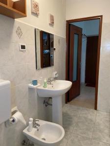 W białej łazience znajduje się umywalka i lustro. w obiekcie IL NON TI SCORDAR DI ME w mieście Valbravenna