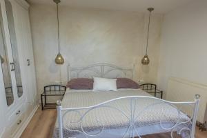 a white bed in a room with two lamps at Casa Angelo in Nerezine