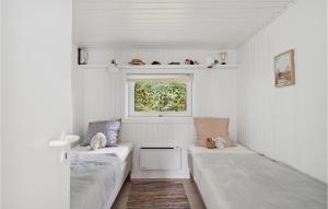 um pequeno quarto com 2 camas e uma janela em 4 Bedroom Gorgeous Home In Hornbk em Hornbæk